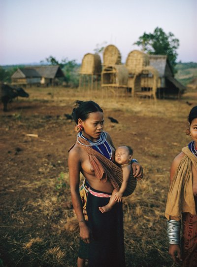 Madre jemer loeu con su hijo en cabestrillo y sarong tradicional de la tribu de las colinas en Phum... de Thomas J. Abercrombie