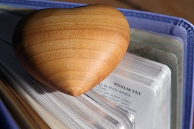 Corazón tallado en madera sobre una Biblia Sagrada de Unbekannt