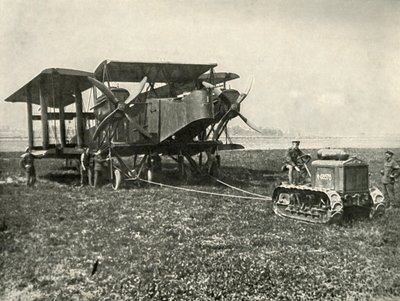 Un pequeño tractor motorizado colocando una enorme máquina de bombardeo de la RAF en posición..., 1919 de Unbekannt