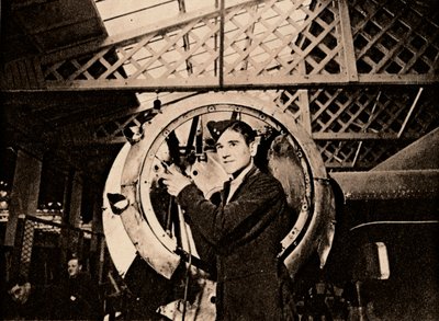 Un trabajador metalúrgico con taladro automático despojando una carcasa de motor, 1940 de Unbekannt