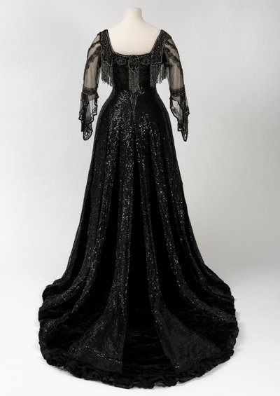 Vestido de noche negro de longitud completa usado por la Reina Alexandra, con decoración de cuentas y lentejuelas e incorporando la cinta de nombre de seda negra y letras doradas de la Reina Alexandra, hecho por Barolet de Knightsbridge, Londres 1908-1910 de Unbekannt