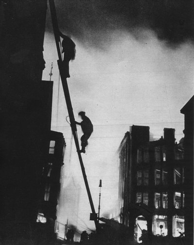 Fuera en el Blitz, silueteados contra la luz de los incendios, los hombres de rescate suben a un edificio en St. de Unbekannt
