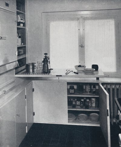 Werner Harting - Cocina con suelo de baldosas negras holandesas, paredes blancas y estantes y armarios empotrados de Unbekannt