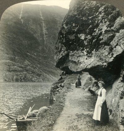 Donde el camino se desliza bajo los acantilados salientes junto a las aguas del Nerofjord, Noruega, c1905 de Unbekannt