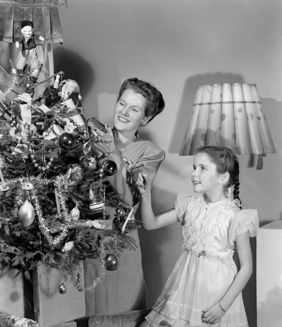 Mujer y niña decorando un árbol de Navidad, c. 1948 de Unbekannt