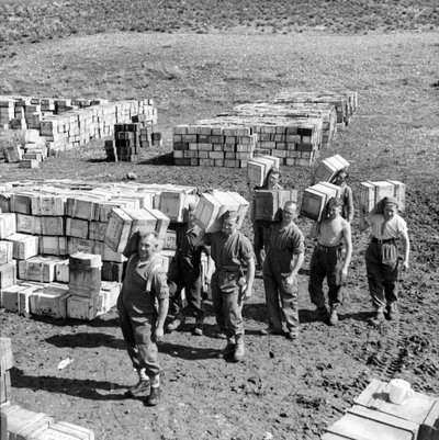 Un depósito de raciones compuestas y hombres llevando más suministros, marzo de 1943 (diapositiva de linterna) de Unbekannt