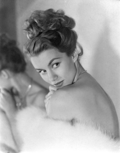 Una joven mira tímidamente por encima del hombro, circa 1948: Guiñando de Unbekannt