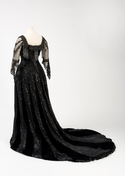 Vestido de noche negro usado por la Reina Alexandra, con decoración de cuentas y lentejuelas e incorporando la cinta de nombre de seda negra y letras doradas de la Reina Alexandra, hecho por Barolet de Knightsbridge, Londres 1908-1910 de Unbekannt