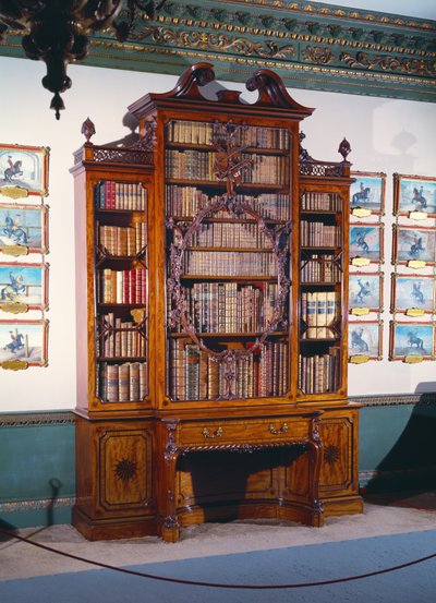 Librero con frente de vidrio con gran estante central decorado con un marco interior tallado elaboradamente que incorpora un violín tallado, flanqueado por dos estantes más cortos y estrechos que descansan sobre una sección inferior de dos armarios lateral de Unbekannt