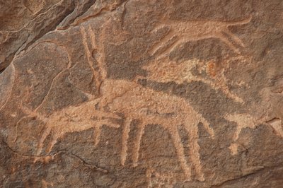 Arte rupestre, Prehistoria: Grabado de un antílope atacado por una manada de perros en el macizo de Uweinat, Egipto (Período de 8000 a 3000 años a.C.). Fotografía de Unbekannt