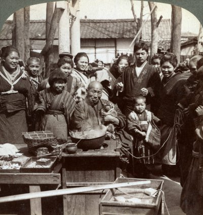 Un artista callejero con un mono divirtiendo a la multitud, Kobe, Japón, 1896 de Underwood and Underwood