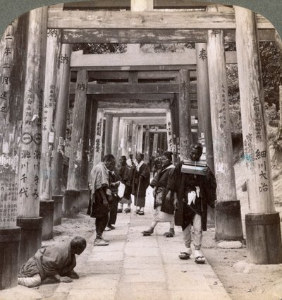 Entrando y saliendo bajo largas filas de torii sagrados, templo sintoísta de Inari, Kioto, Japón, 1904 de Underwood and Underwood