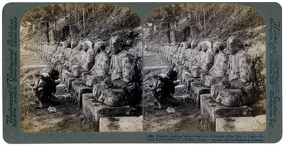 Campesino rezando ante una fila de estatuas del Dios de la Luz, río Daiya, Nikko, Japón, 1904 de Underwood and Underwood