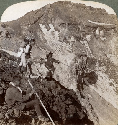 Asomándose desde el borde cubierto de lava hacia el cráter del Monte Fuji, Japón, 1904 de Underwood and Underwood