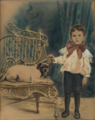 Niño con perro en una silla de Unidentified