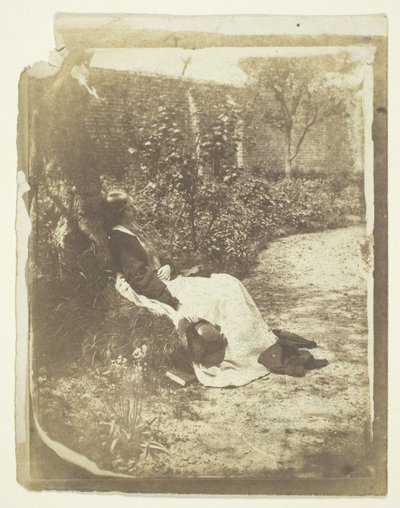 Sra. Craik reclinada en el jardín con sombrero y libro de Unknown