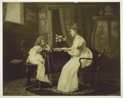 Mujer y niño jugando al dominó en la mesa de Unknown