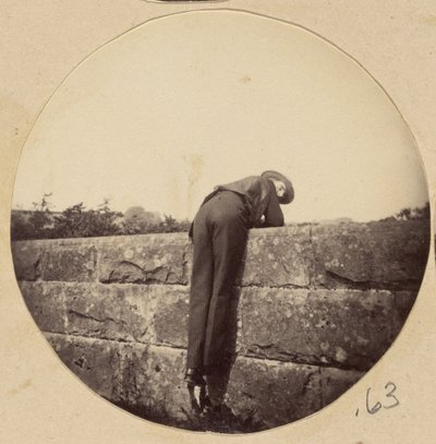 [Hombre con sombrero inclinado sobre un muro de piedra] de Unknown artist