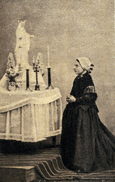 Bernadette Soubirous arrodillada ante un altar con la Virgen de Unknown photographer