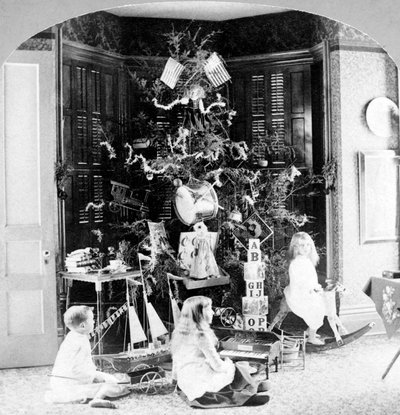 Niños reunidos al pie del árbol rodeados de regalos en la mañana de Navidad de Unknown photographer