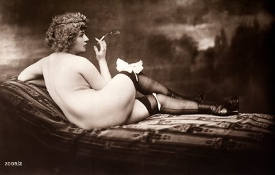 Retrato de una joven que posa desnuda, de espaldas, mientras fuma un cigarrillo de Unknown photographer
