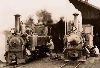 Dos locomotoras de vapor en mantenimiento por dos trabajadores. de Unknown photographer