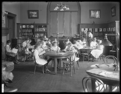 Niños leyendo en la sala de lectura de una sucursal no identificada de la Biblioteca Pública del Borough de Queens, c.1910 de William Davis Hassler