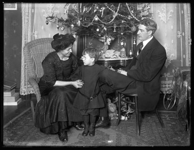 Dan Seymour y familia en pose informal, sentados bajo un árbol de Navidad, Navidad de 1912 de William Davis Hassler