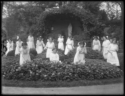 Clase graduada de niñas del Asilo de Huérfanos Católico Romano en el jardín de flores, frente a la gruta de la Virgen María, 1912 de William Davis Hassler