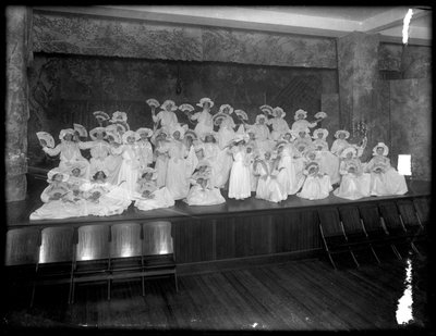 Grupo de niñas pequeñas posando en un pequeño escenario con abanicos, probablemente el Orfanato Católico Romano, Kingsbridge, Bronx, c.1911 de William Davis Hassler