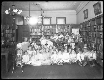 Retrato de grupo de niños en la sala de lectura de una sucursal no identificada de la Biblioteca Pública del Borough de Queens, c.1910 de William Davis Hassler
