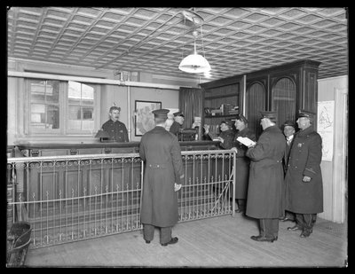 Interior de una comisaría no identificada, mostrando a los oficiales y la recepción, c.1913-14 de William Davis Hassler