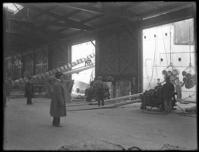 Interior de almacén en el muelle, cabrestantes eléctricos portátiles siendo usados para descargar el barco, 31st Street, Brooklyn, 1912 de William Davis Hassler