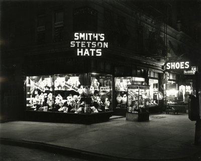 Fachadas de tiendas iluminadas anunciando sombreros Stetson de Smith, zapatos, licores, c.1910-21 de William Davis Hassler