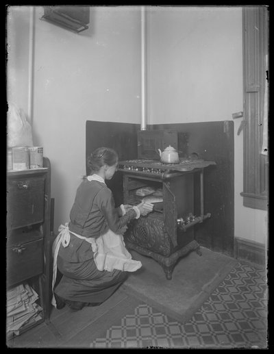 La señorita Bates sacando pan del horno, c.1913 de William Davis Hassler