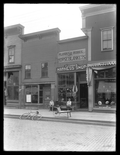 Tres niños no identificados fuera de la tienda de arneses de Fleming, posiblemente Cochranton, Pensilvania, c.1913 de William Davis Hassler
