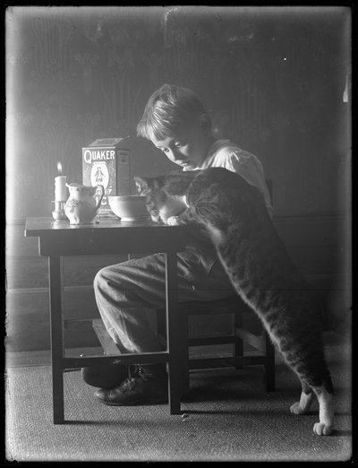 William Gray Hassler y Reddy el gato, comiendo cereal de arroz inflado Quaker, c.1912 de William Davis Hassler