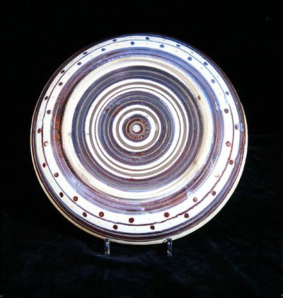 Plato con círculos concéntricos de blanco, azul, púrpura y oro, pintado por Charles Passenger de William de Morgan