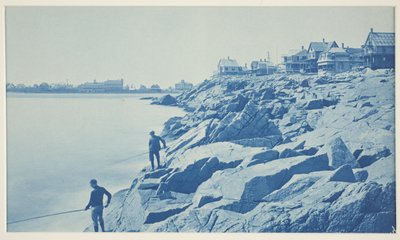 Dos hombres pescando desde rocas en un balneario de William H. Cades