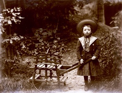 Niña con carrito en un jardín, principios del siglo XX de . .