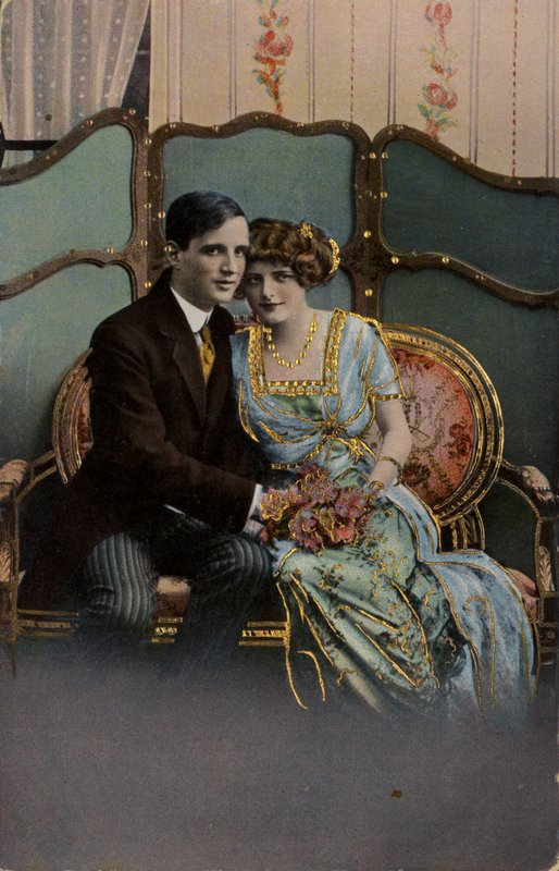 Pareja con un ramo de flores, sentados en un sofá de English Photographer