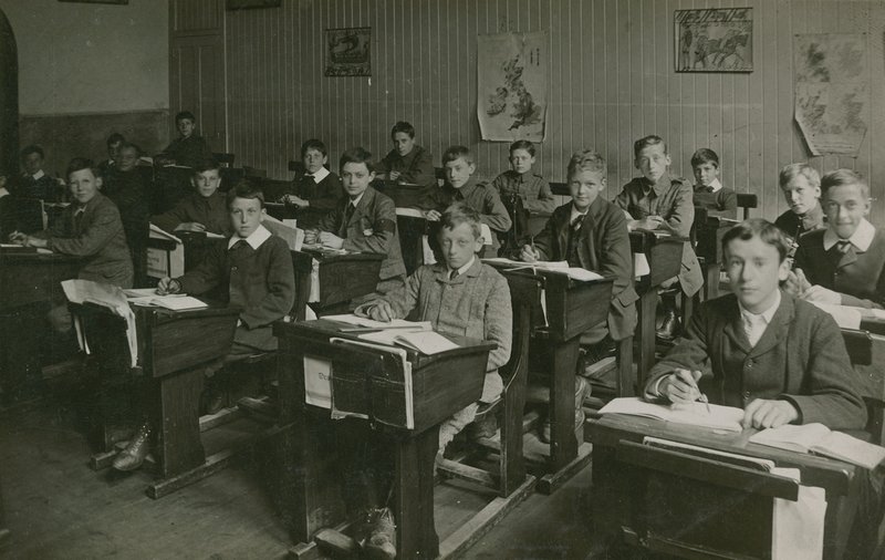 Alumnos varones sentados detrás de sus escritorios durante una lección en la escuela de English Photographer