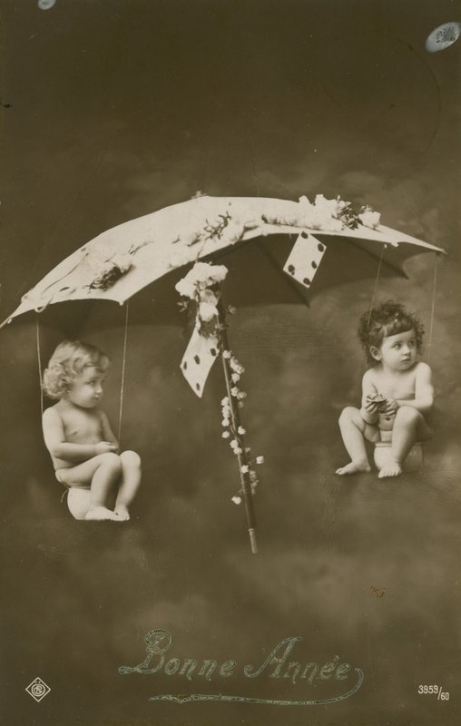 Tarjeta de Año Nuevo con dos bebés colgando de un paraguas de French Photographer