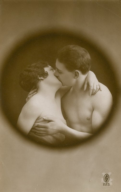 Joven hombre y mujer besándose vistos a través de una mirilla de French Photographer