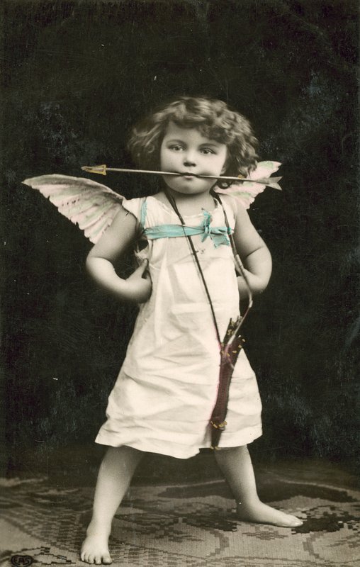 Niño pequeño, vestido como Cupido, con una flecha en la boca de French Photographer
