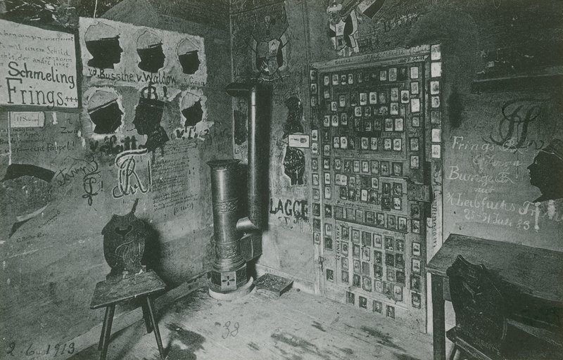 Habitación con paredes cubiertas de graffiti que hacen referencia a importantes figuras contemporáneas como Bussche y Waldow. Tarjeta postal enviada en 1913. de German Photographer