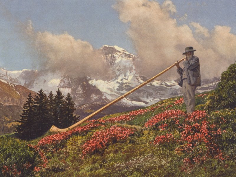 Suiza: Un soplador de Alphorn, la Jungfrau al fondo (foto en color) de Jean Gaberell