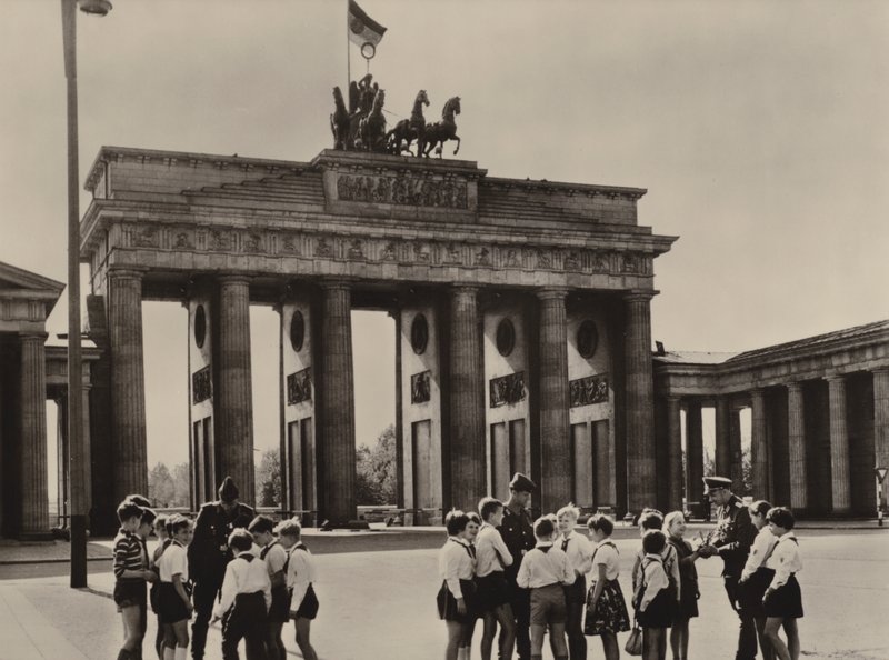 Jóvenes pioneros vienen a la Puerta de Brandeburgo, el símbolo de Berlín, para ver a sus amigos, los guardias fronterizos (foto en blanco y negro) de Photographer German
