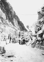 Excavadoras trabajando en una cantera de mármol en los Alpes Apuanos, Toscana (foto en b/n)
