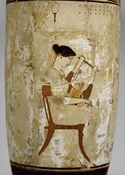 Lekythos de fondo blanco ático decorada con una mujer tocando una cítara (terracota vidriada)